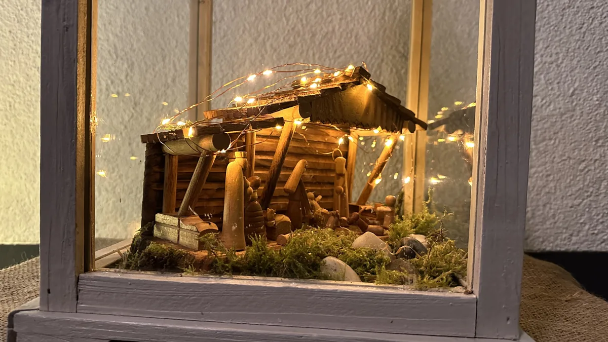 Kleine Holzkrippe mit Lichterkette in einer Laterne auf dem Krippenweg Ottersdorf